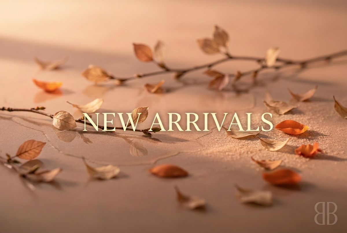 New Arrivals lettering on a warm background with delicate autumn leaves